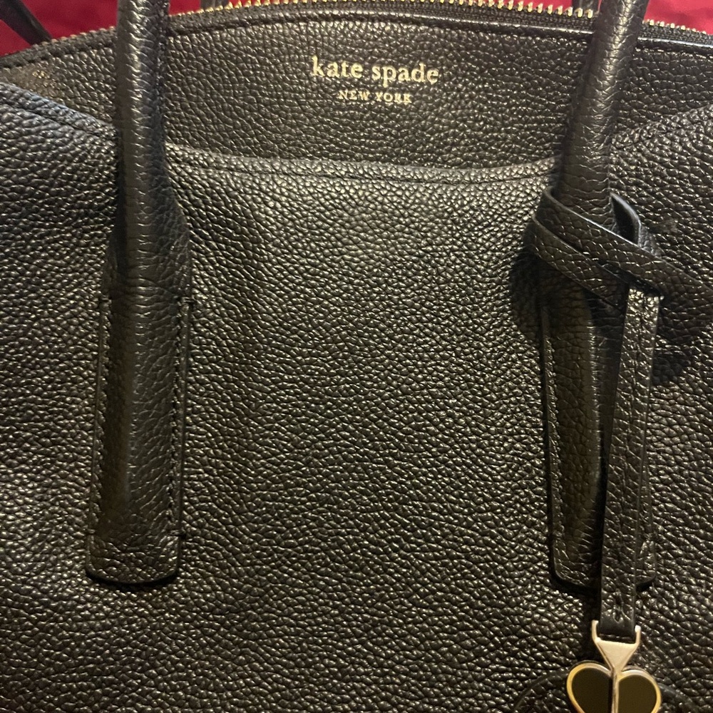 Black Kate Spade satchel with cross body strap.